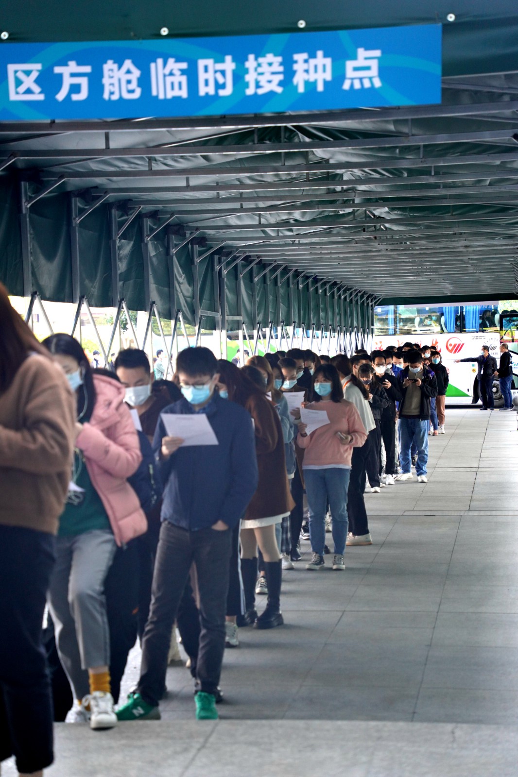 当天,浙江中医药大学学生也进行了集体接种,图为在排队测温进场
